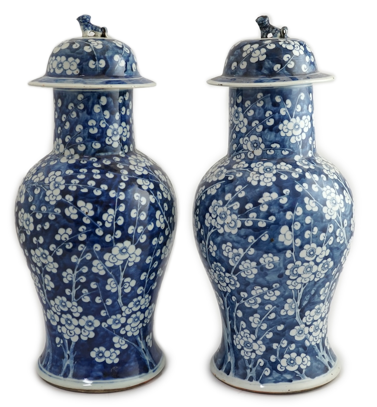 A pair of large Chinese blue and white ‘prunus’ baluster vases and covers, 19th century